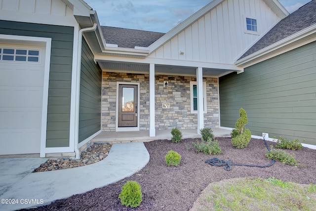 view of exterior entry with covered porch and a garage