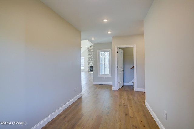 hall with vaulted ceiling and light wood-type flooring