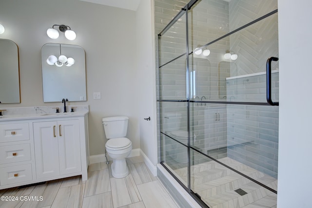 bathroom featuring vanity, toilet, and a shower with door