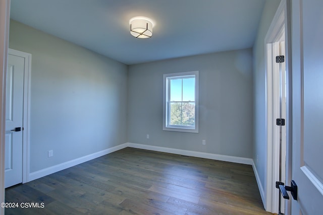 spare room with dark hardwood / wood-style flooring