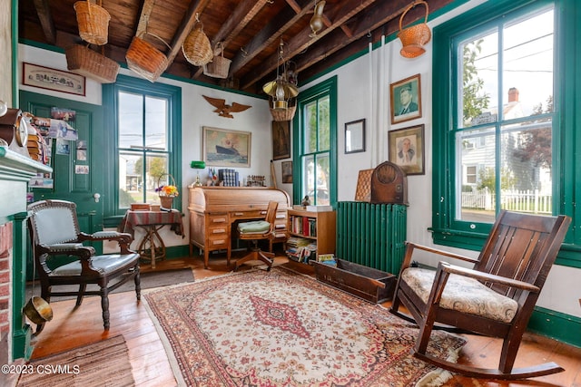 sitting room featuring beamed ceiling, light hardwood / wood-style floors, and wooden ceiling