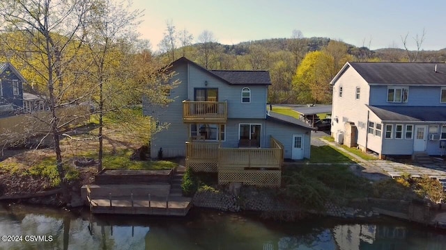 rear view of property featuring a balcony and a deck with water view