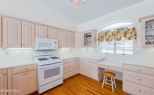 kitchen with tasteful backsplash, white appliances, lofted ceiling, and light hardwood / wood-style floors