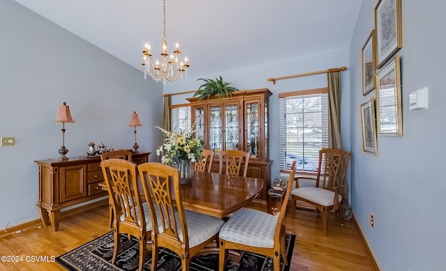 dining space with a chandelier and light hardwood / wood-style flooring