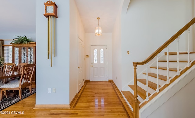 entrance foyer featuring hardwood / wood-style floors, a high ceiling, and a notable chandelier