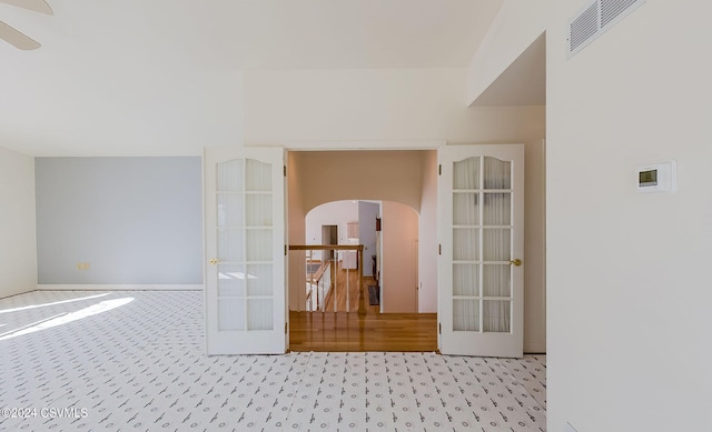 unfurnished room featuring french doors and light colored carpet