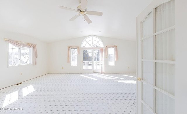 unfurnished room with ceiling fan, vaulted ceiling, a wealth of natural light, and carpet floors