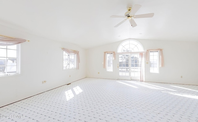 unfurnished room with ceiling fan, light colored carpet, plenty of natural light, and vaulted ceiling