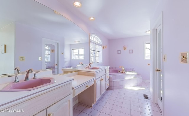 bathroom featuring tile patterned floors, vanity, and a relaxing tiled tub