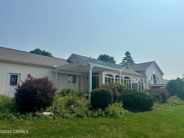 view of property exterior with a yard and a pergola