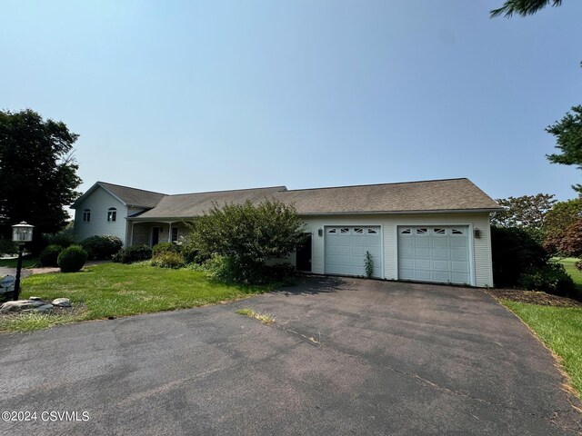 ranch-style home with a garage and a front yard