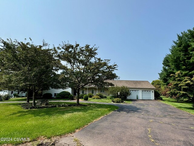 ranch-style home featuring a garage and a front lawn