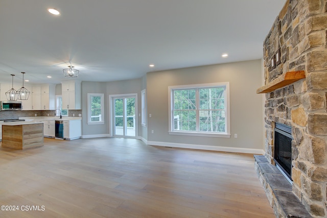 unfurnished living room featuring light hardwood / wood-style floors, sink, and a fireplace