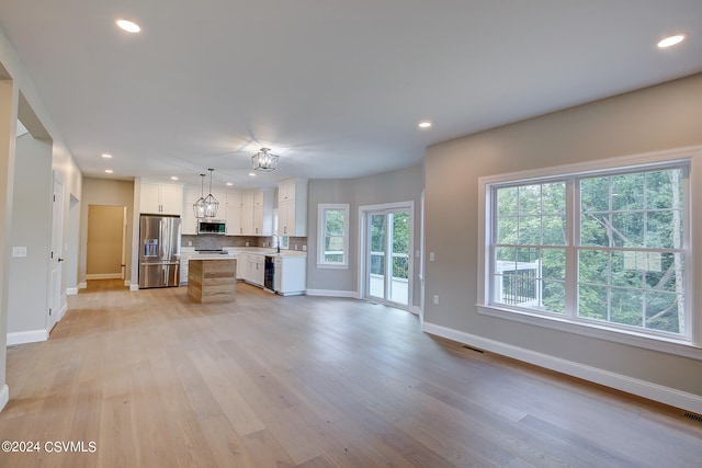 unfurnished living room with sink and light hardwood / wood-style flooring