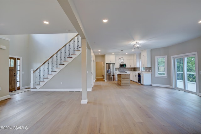 unfurnished living room featuring sink and light wood-type flooring