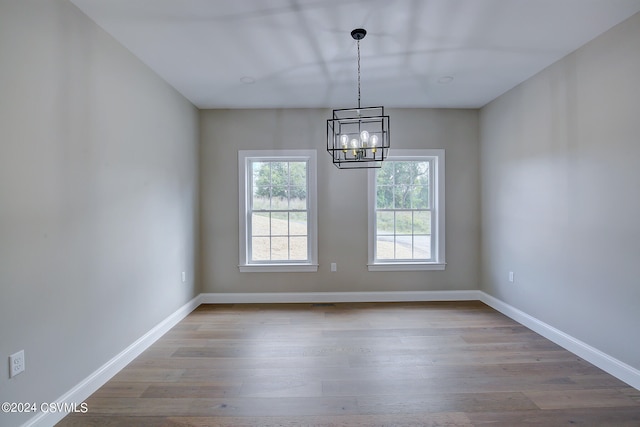 empty room featuring hardwood / wood-style floors and a chandelier