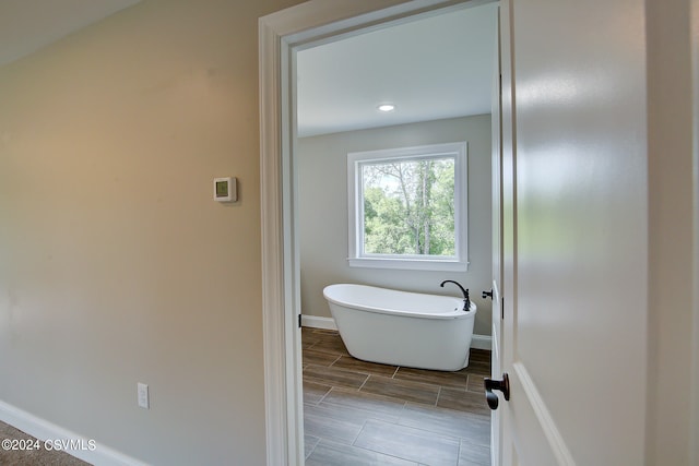 bathroom with tile patterned flooring and a tub to relax in