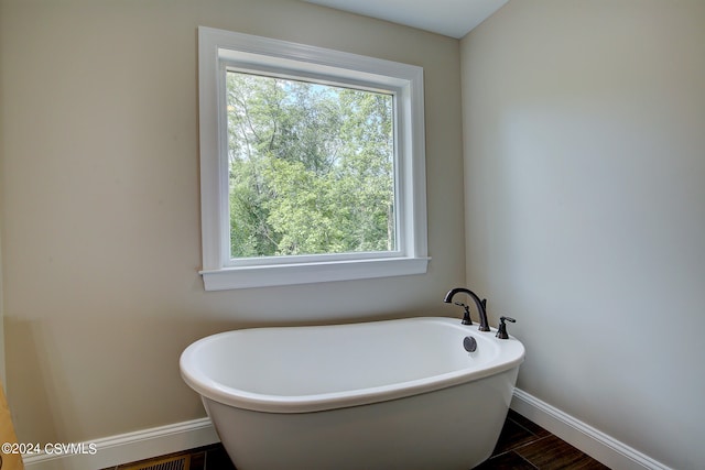 bathroom with a bath and tile patterned floors