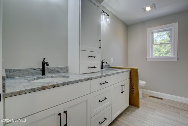 bathroom with tile patterned flooring, vanity, and toilet