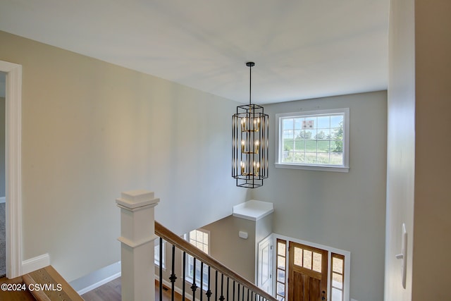 stairway featuring hardwood / wood-style floors and a chandelier