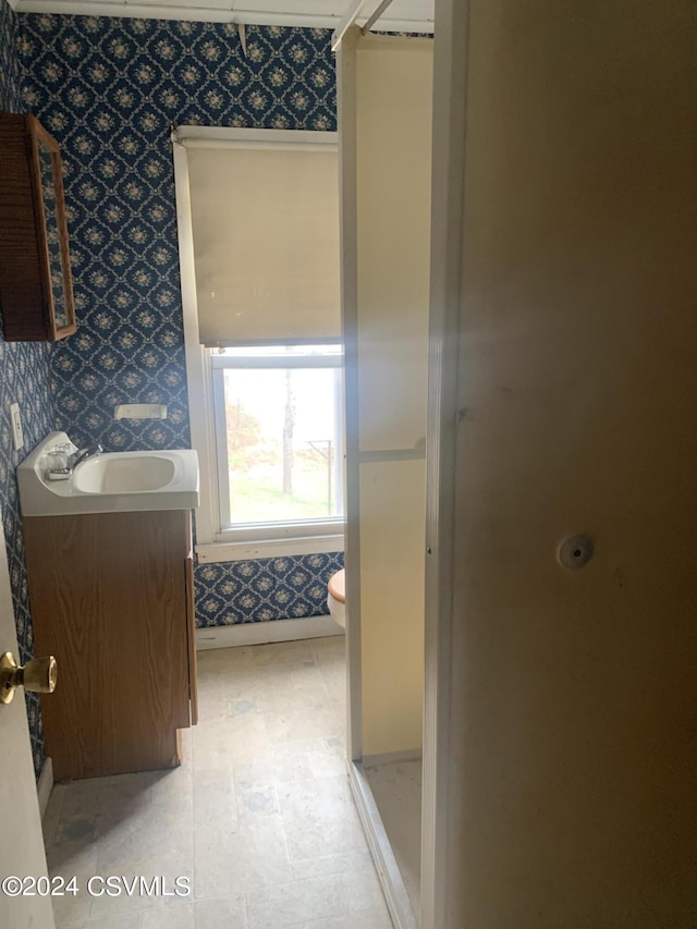 bathroom with toilet, vanity, and tile flooring