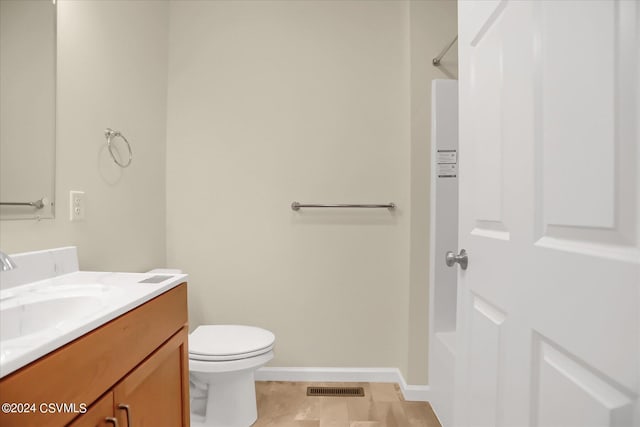 bathroom featuring tile patterned flooring, vanity, and toilet