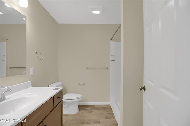 bathroom with walk in shower, vanity, and toilet