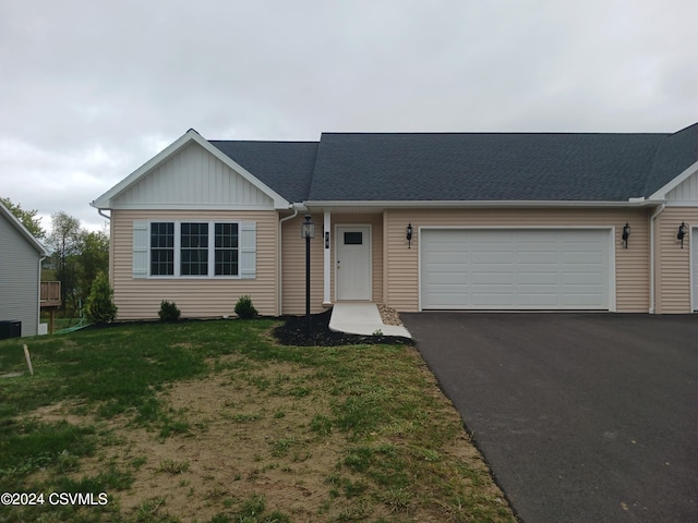 single story home with a front yard and a garage