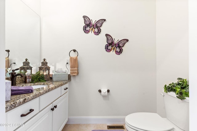 bathroom featuring toilet, tile flooring, and vanity