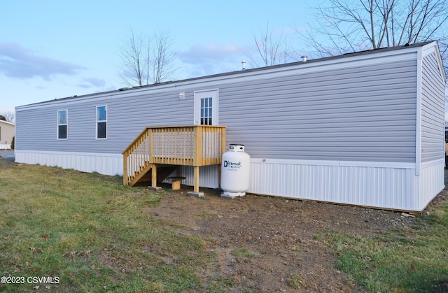 back of house featuring a deck and a lawn