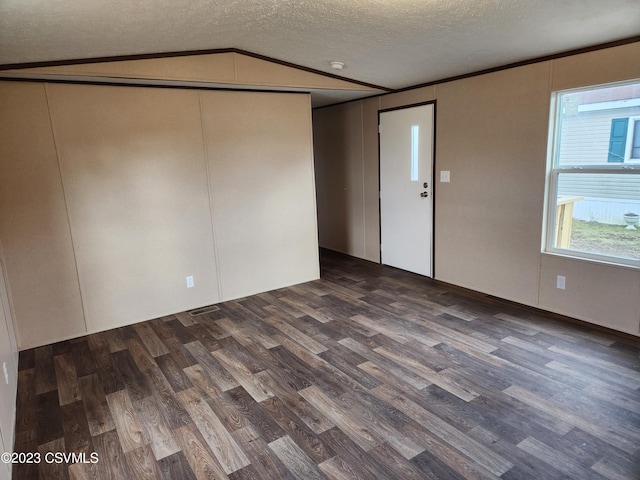 unfurnished room with dark hardwood / wood-style floors, a textured ceiling, and lofted ceiling