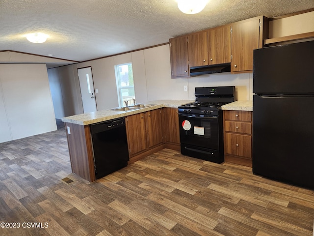 kitchen with kitchen peninsula, a textured ceiling, black appliances, and dark hardwood / wood-style flooring