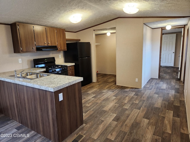 kitchen with a textured ceiling, vaulted ceiling, black appliances, and dark hardwood / wood-style flooring