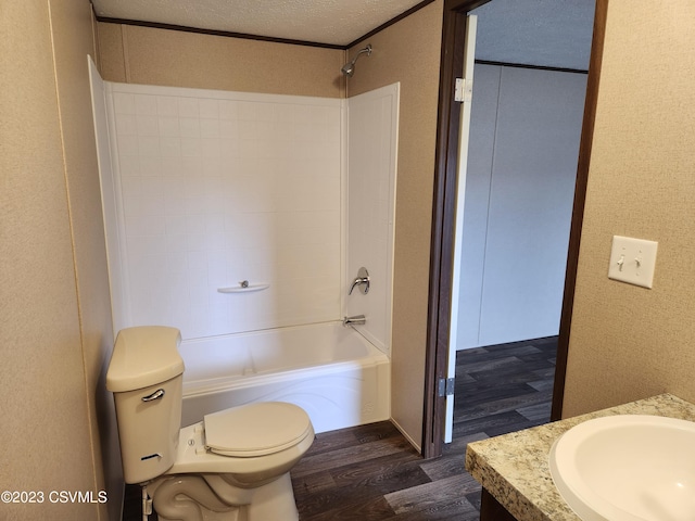 full bathroom with toilet, hardwood / wood-style floors, shower / washtub combination, a textured ceiling, and vanity