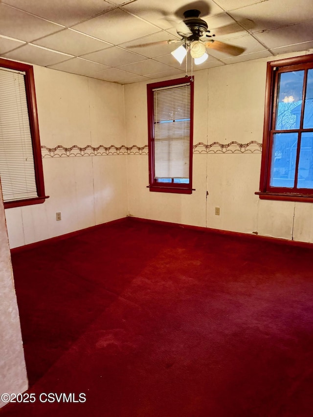 unfurnished room with dark colored carpet, a paneled ceiling, and ceiling fan