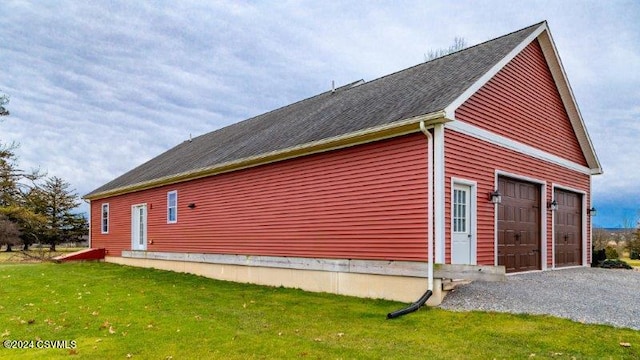 view of side of home featuring a garage and a yard