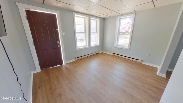 entrance foyer with a baseboard heating unit, a paneled ceiling, and hardwood / wood-style floors