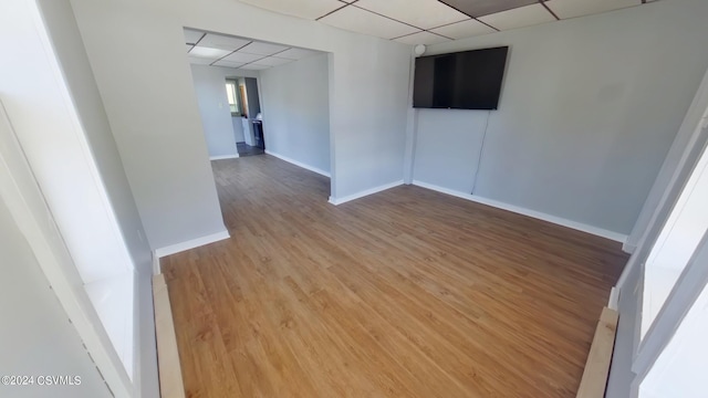 unfurnished room featuring hardwood / wood-style floors and a paneled ceiling