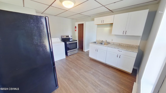 kitchen featuring washer / dryer, electric stove, white cabinetry, light wood-type flooring, and a paneled ceiling