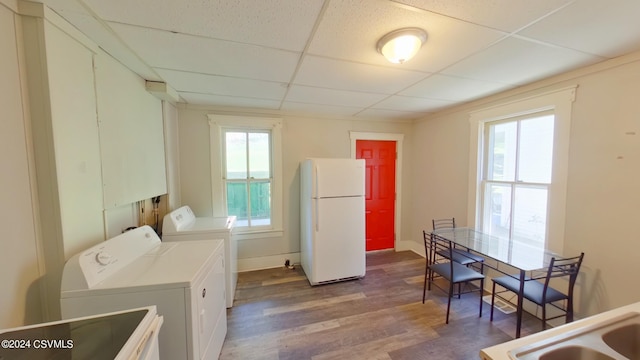 washroom with washing machine and dryer and hardwood / wood-style flooring