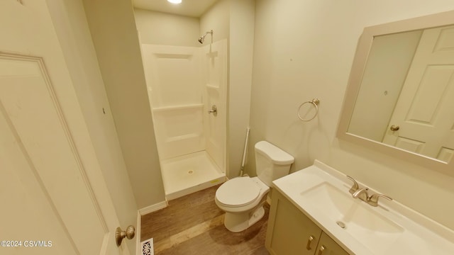 bathroom featuring a shower, oversized vanity, toilet, and hardwood / wood-style flooring