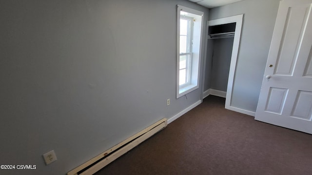 unfurnished bedroom with dark carpet, a closet, and a baseboard radiator