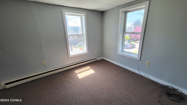 carpeted empty room featuring a baseboard radiator