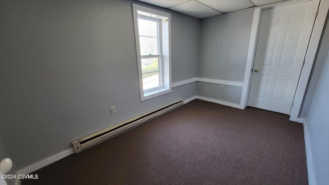 empty room with dark carpet and a baseboard radiator