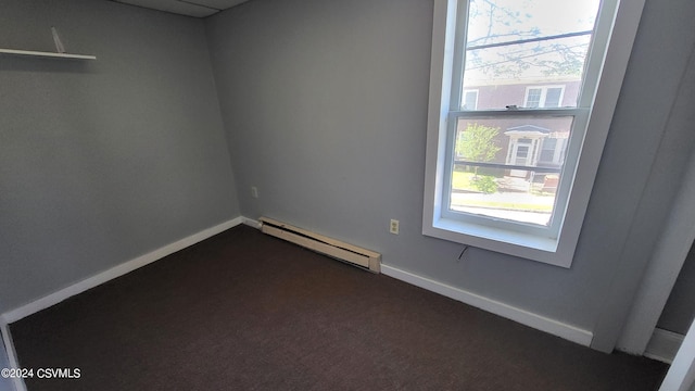 unfurnished room featuring carpet and a baseboard heating unit