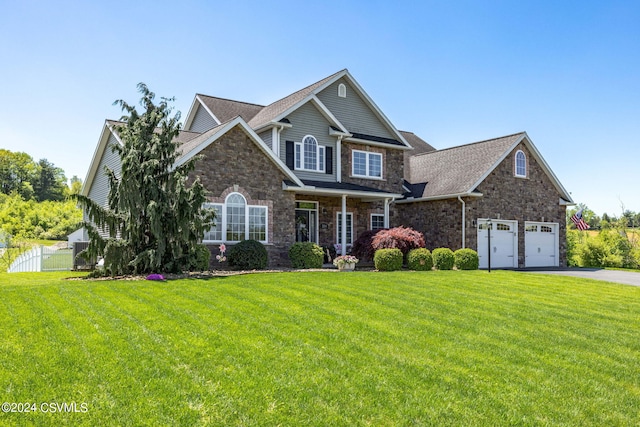 craftsman inspired home featuring a garage and a front yard