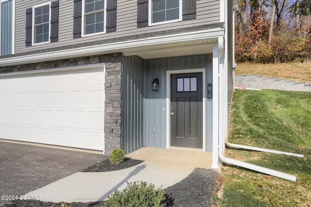 doorway to property featuring a lawn and a garage