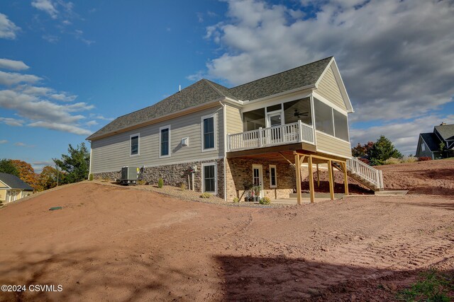 rear view of house with central AC and a sunroom