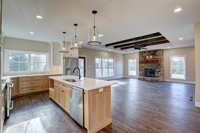 kitchen with a center island with sink, dark wood-type flooring, stainless steel appliances, and a wealth of natural light