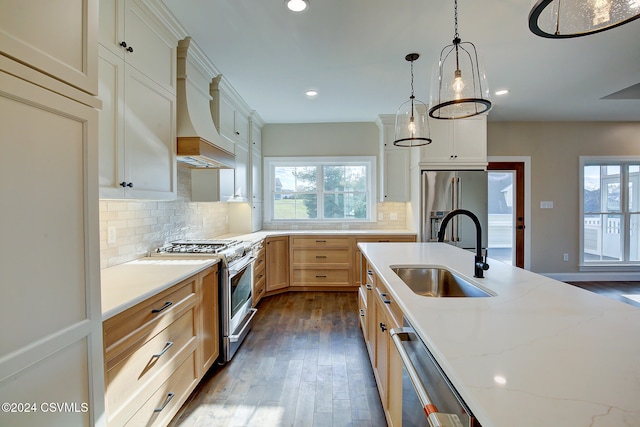 kitchen with premium appliances, sink, decorative light fixtures, custom range hood, and dark wood-type flooring